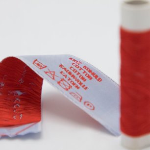 Kledinglabel middenvouw met rechts de onderhoudssymbolen Kledinglabel